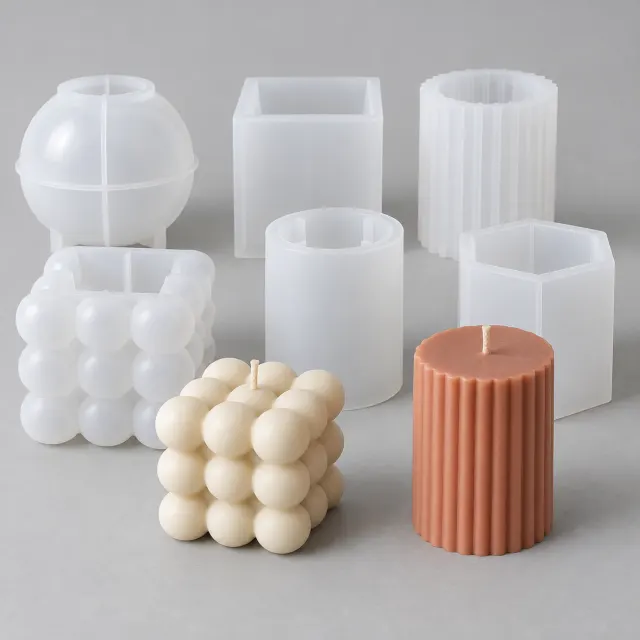 Seis moldes de silicona para velas de formas geométricas junto a velas desmoldadas de cera color crema