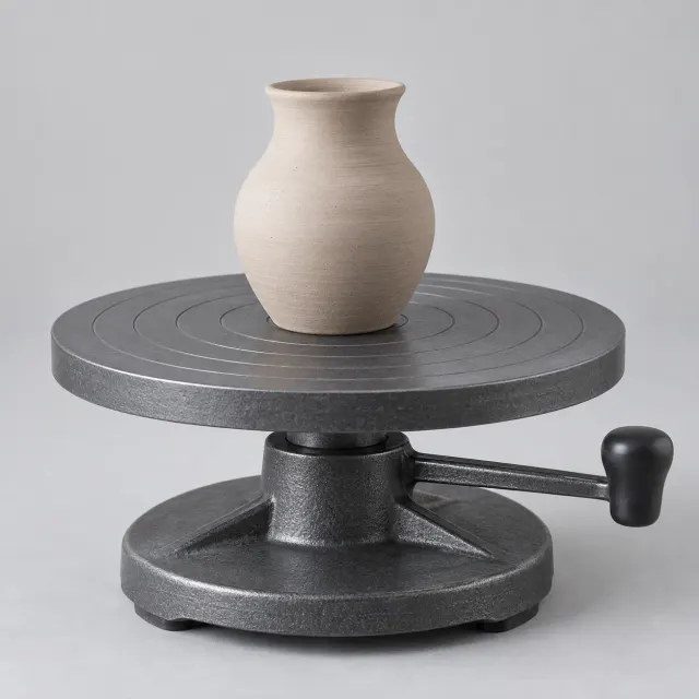 Torno de mesa manual para cerámica con plato giratorio de aluminio y una pieza de arcilla en proceso de modelado